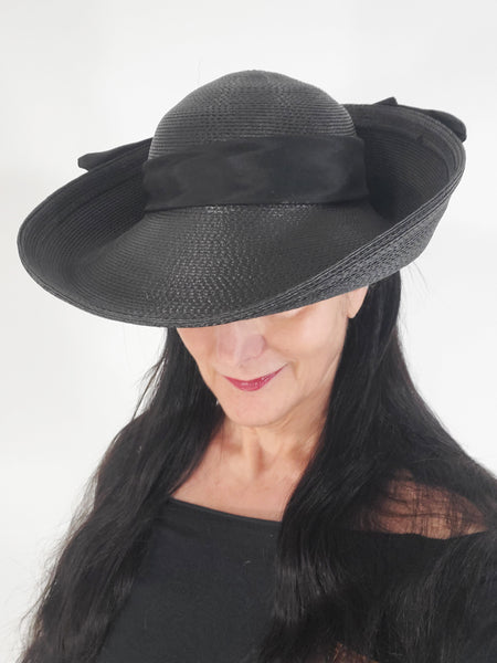 Black straw 1980s wide brim hat on a person
